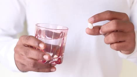 persona que toma una pastilla con agua