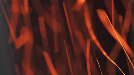 fast movement of bright red glowing particles. blurry long burning trail from sparks flying out of the fire. abstract industrial background