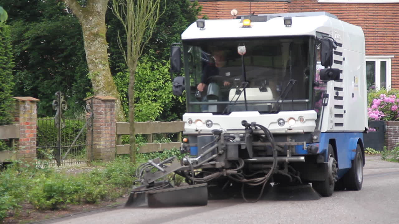 Street sweeper cleaning street in suburban neighbourhood