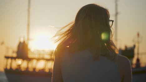 attractive woman watching the boats at sunset