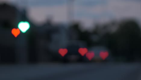 Beautiful-hearts-bokeh-from-moving-car-and-traffic-lights-at-the-evening,-Valentines-Day-or-social-media-Like-background-concept