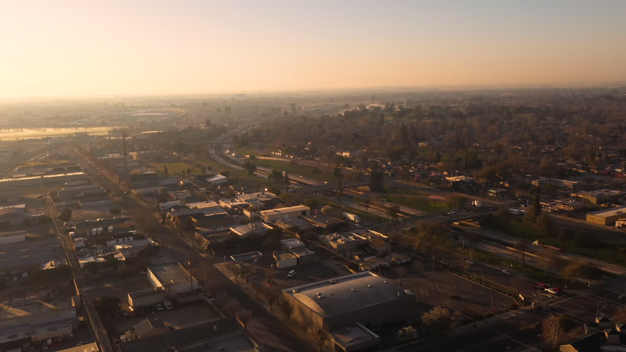 Modesto California Stanislaus County. Drone over city at sunrise with cars driving on interstate freeway 99