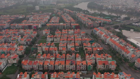 Imágenes-De-Drones-De-Madrugada-Con-Niebla-Y-Smog-Volando-Hacia-Atrás-Sobre-Desarrollos-De-Viviendas-De-Villas-Urbanas-En-El-Distrito-Siete-De-Saigón,-Ciudad-De-Ho-Chi-Minh,-Vietnam