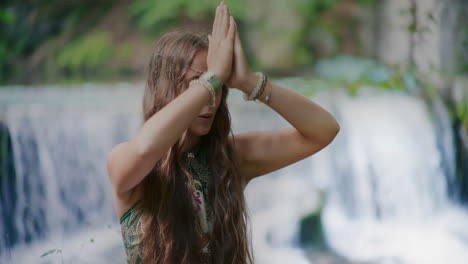 retrato de una mujer meditando frente a una cascada