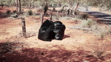 three black garbage bags dumped in the australian outback