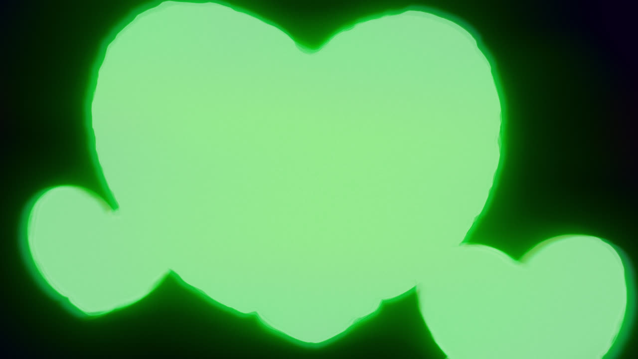 Green energy heart shapes on a dark background