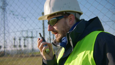 close-up, man wearing personal protective equipment and using radio