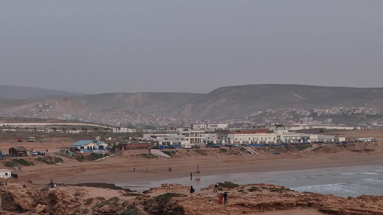 Vista aérea de una zona de playa en Marruecos con olas y gente caminando