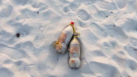 coca cola coke plastic bottles lying in the sand