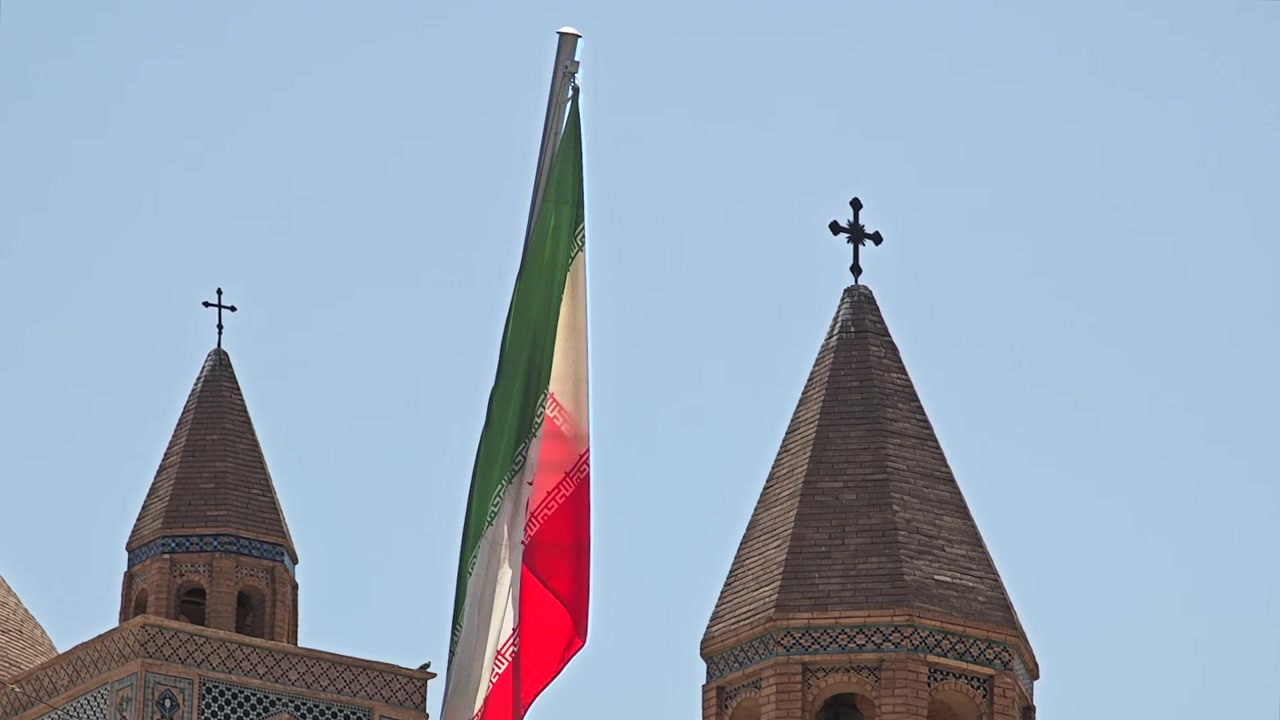 Bandiera iraniana che sventola tra due campanili