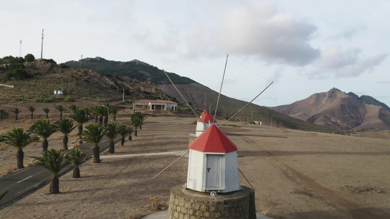 volando a través de aspas de viejos molinos de viento de madera en la cima de una colina en porto santo