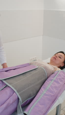 terapeuta de cosmetología médico haciendo procedimiento de presoterapia tratamiento para mujer en un salón de belleza