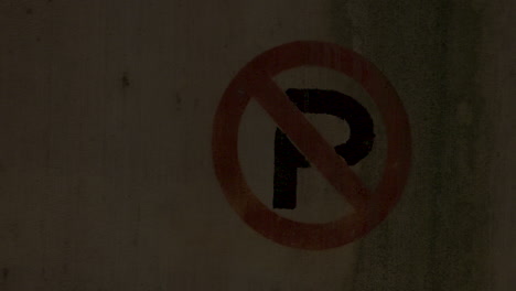 pan right to a parking garage pillar with the "no parking" symbol