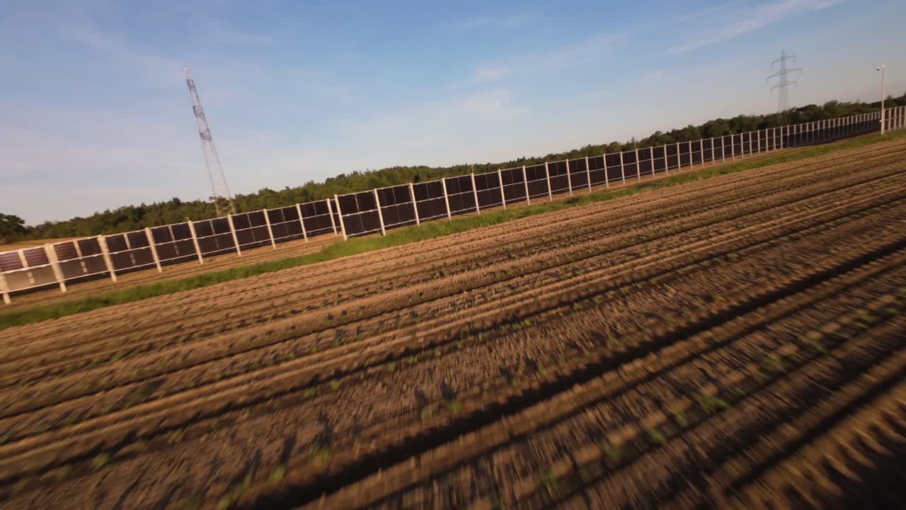 Solar farm glows under golden evening light in expansive Austrian agricultural terrain