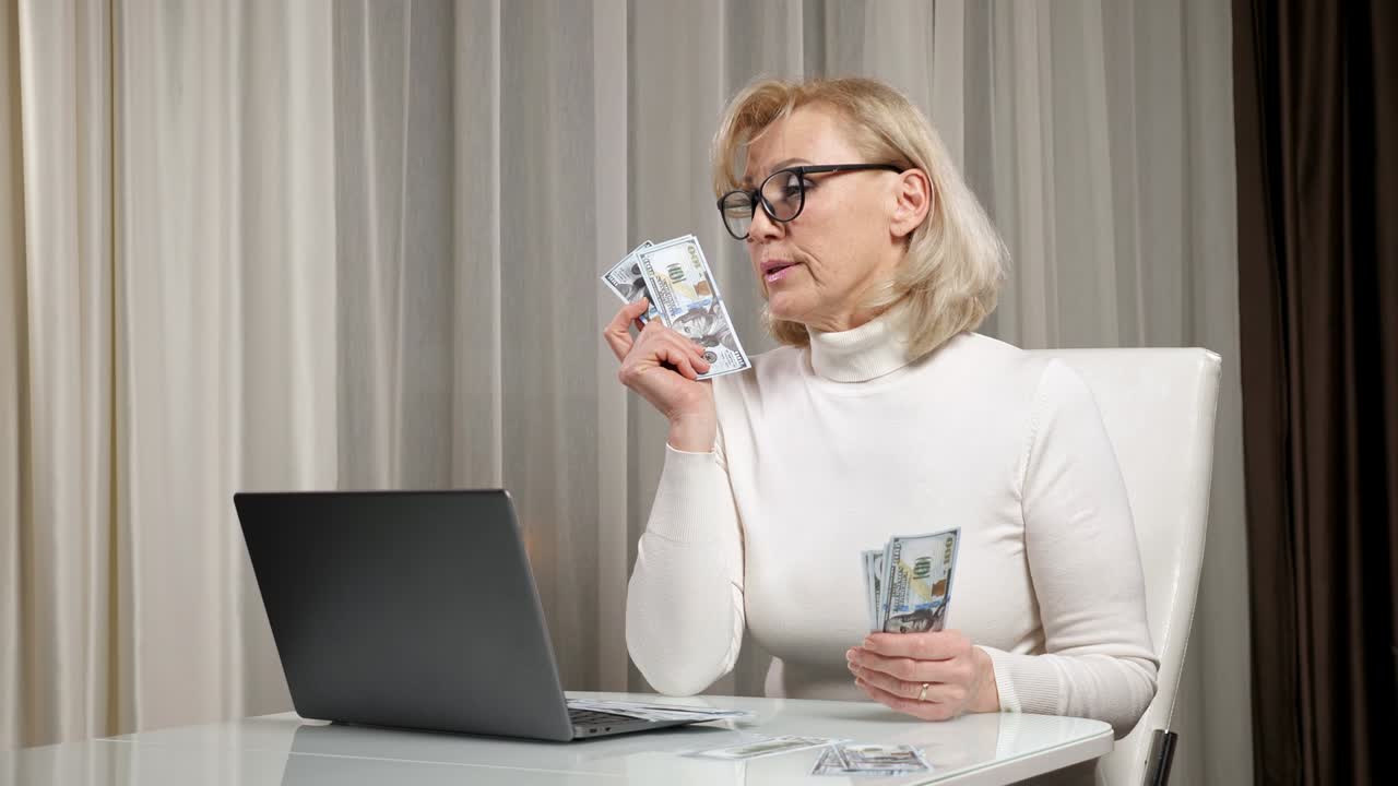 пожилая женщина подсчитывает и распределяет деньги для оплаты счетов