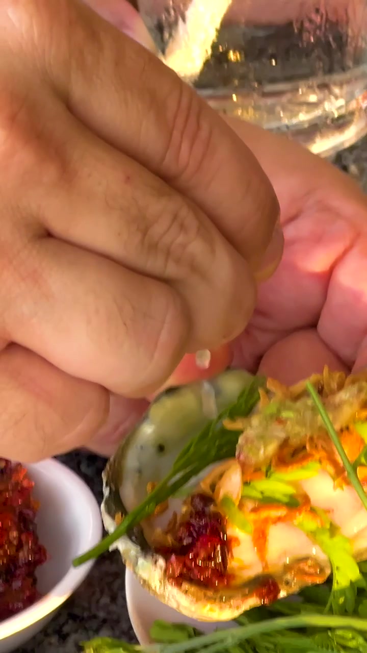 ハーブとスパイスで牡蠣を調理する手