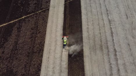 combine harvester slowly being followed as it harvests feed beans