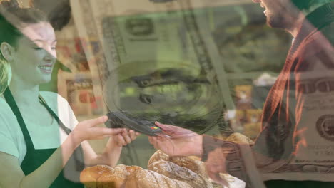 digital composite of man paying in cafe amidst animated finance data and falling dollars.