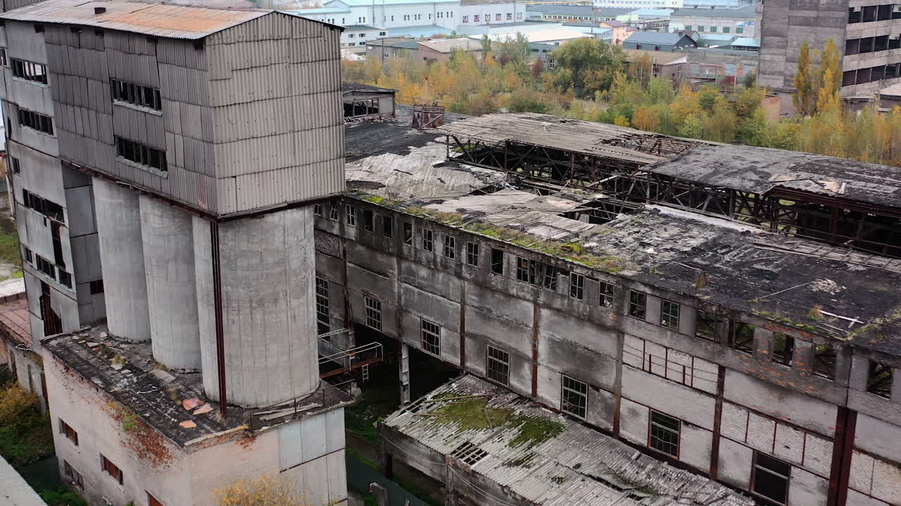 Old abandoned factory. Exterior of ruined buildings with many holes in the roof after military activity. Damaged buildings outdoors. Aerial view.
