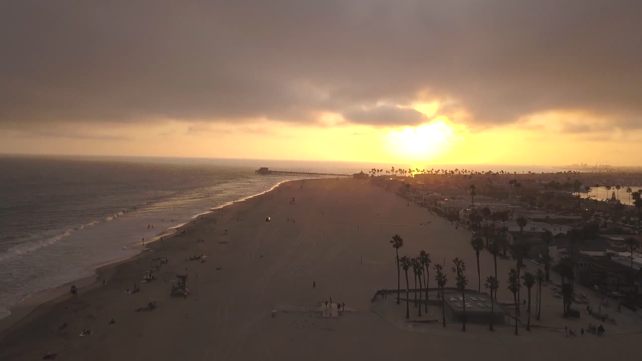 un vuelo sobre una playa del sur de california al atardecer
