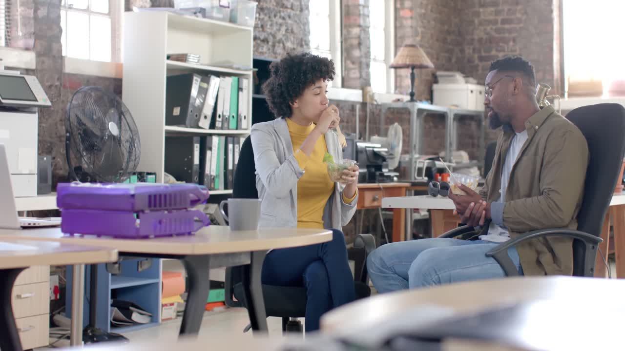 diversos colegas felices hablando y almorzando en la oficina en cámara lenta