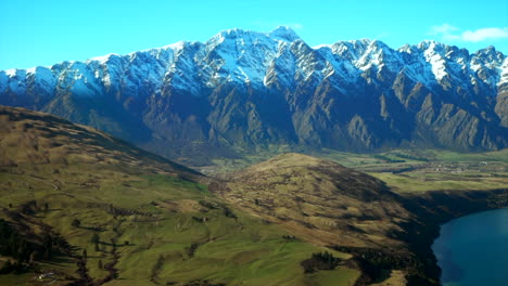 the remarkable's south island queenstown new zealand snowy mountain peaks green valley aerial drone winter beautiful sunny morning afternoon lake wakatipu wanaka landscape to the right movement