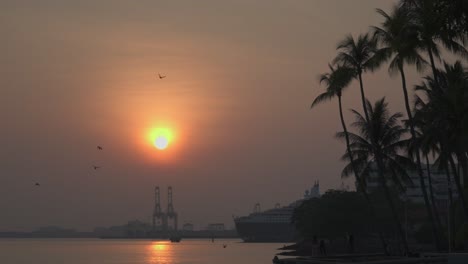 Impresionante-Belleza-De-Un-Impresionante-Amanecer,-Proyectando-Su-Brillo-Dorado-Sobre-Un-Bullicioso-Puerto-Industrial-Y-De-Cruceros.