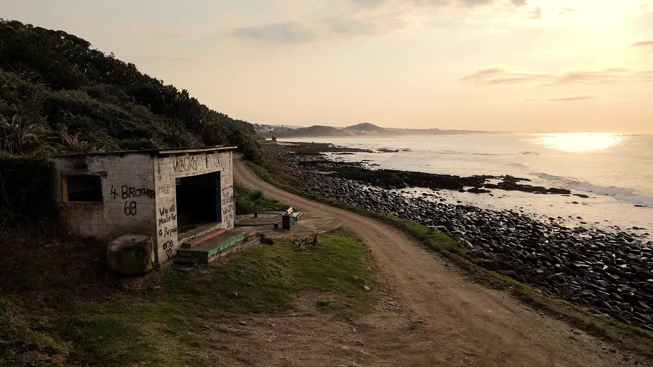 refugio abandonado a orillas del mar con impresionantes obras de arte de graffiti, la serena belleza del amanecer, sudáfrica