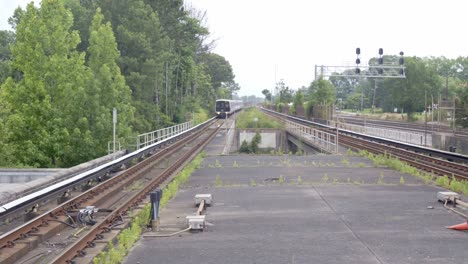 Der-Pendlerzug-Kommt-Am-Bahnhof-An,-Fährt-Durch-Die-Bäume-Und-Kommt-Am-Bahnsteig-An,-Um-Transitpendler-In-Atlanta,-Georgia,-USA,-Abzuholen