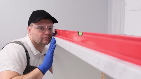 a man collects kitchen furniture repair of the kitchen using a construction laser