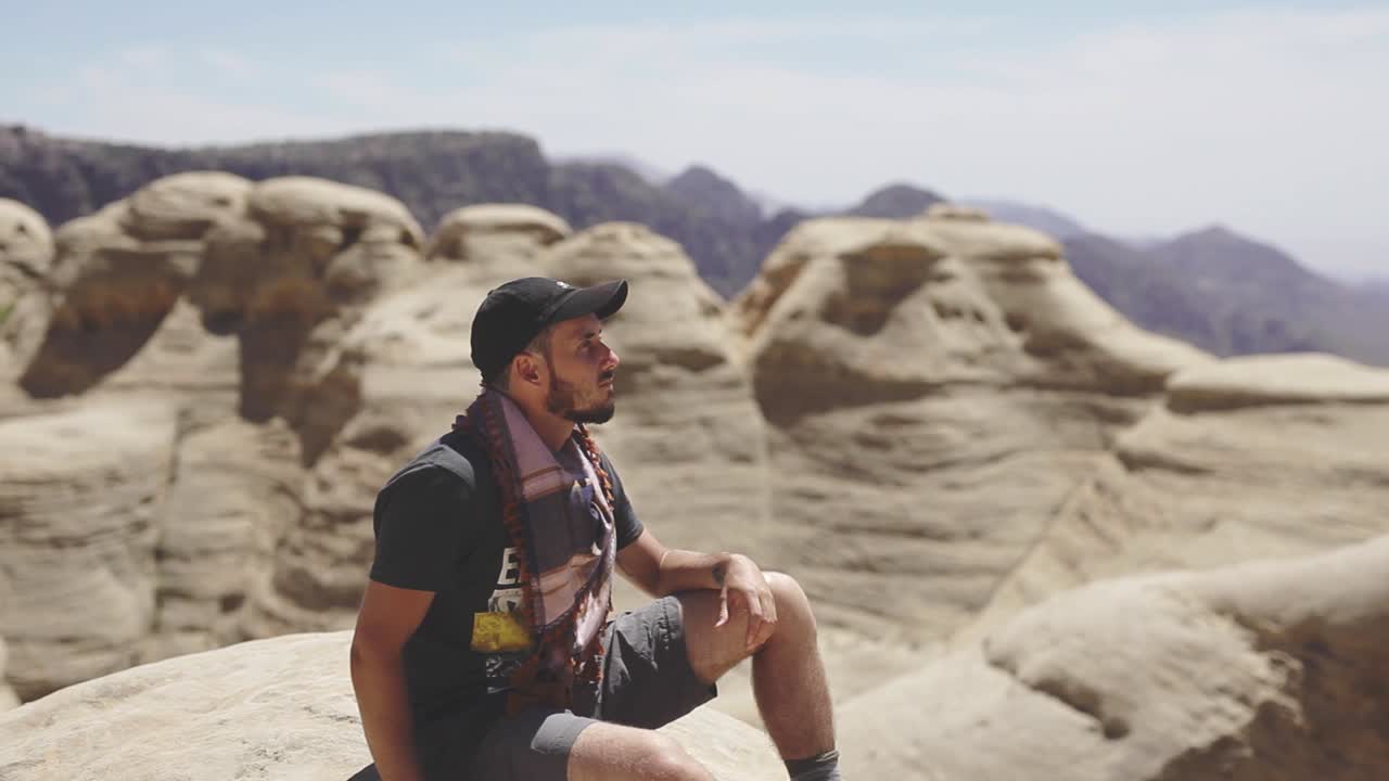 Adventurer enjoying the views, mountains background, peaceful atmosphere, nature reserve in Jordan, static shot
