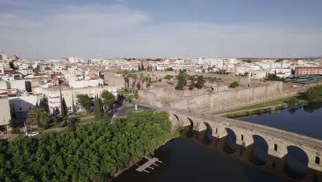 Aerial-view-orbiting-Alcazaba-of-Mérida-Muslim-fortification-and-roman-bridge-on-the-Gaudiana-river,-Spain