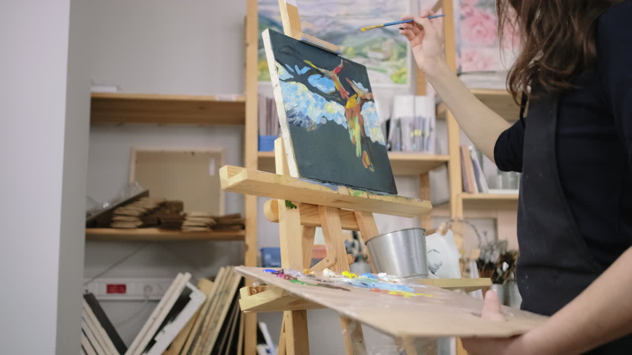 mujer pintando un pájaro colorido en lienzo