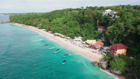 aerial view of stunning tropical beach with turquoise water and lush cliffside