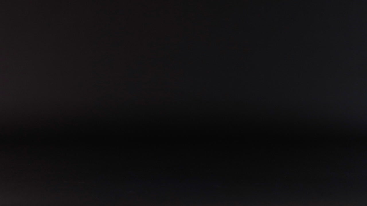Tennis ball bouncing against a dark background