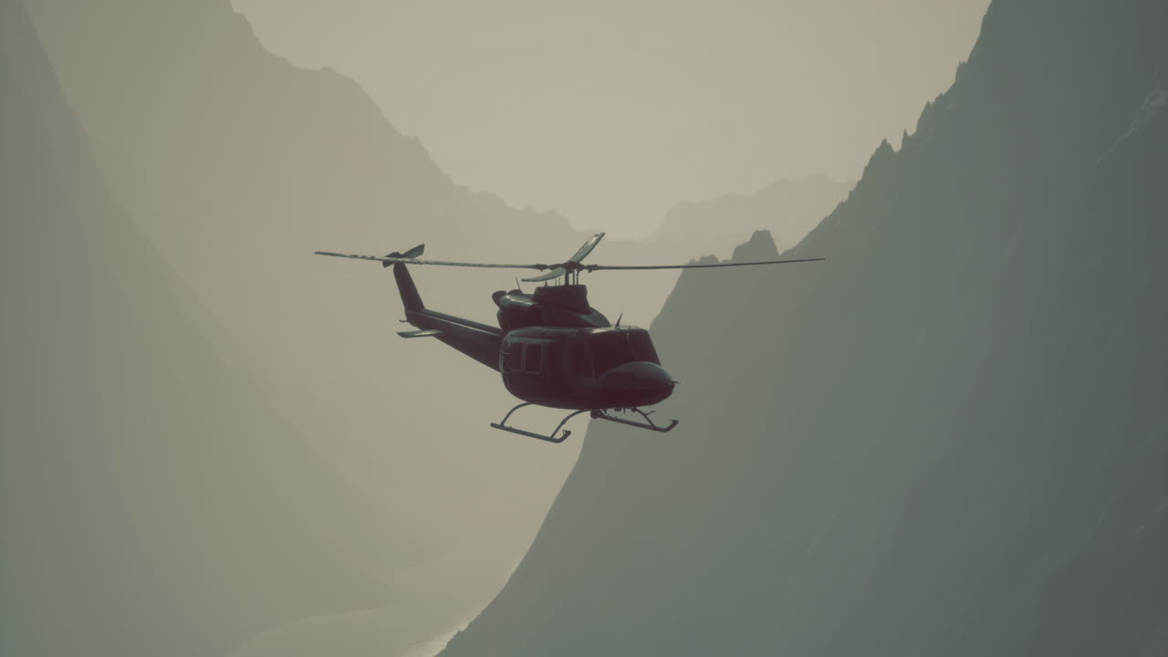 Helicopter flying over mountains during sunrise in a stunning landscape