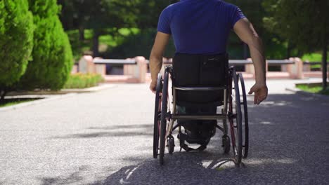 disabled man driving his wheelchair outdoors in slow motion.