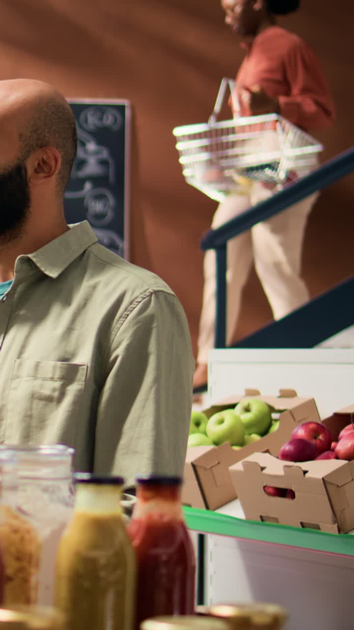 Vídeo vertical: el dueño de la tienda le da limones a un hombre