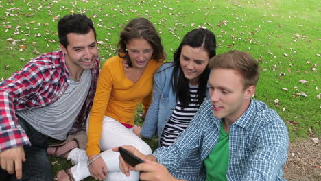 estudiantes tomando una selfie en el césped