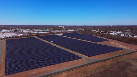 Eine-Luftaufnahme-über-Ein-Großes-Solarfeld-Auf-Long-Island,-New-York-An-Einem-Sonnigen-Tag-Mit-Blauem-Himmel-Und-Ohne-Wolken