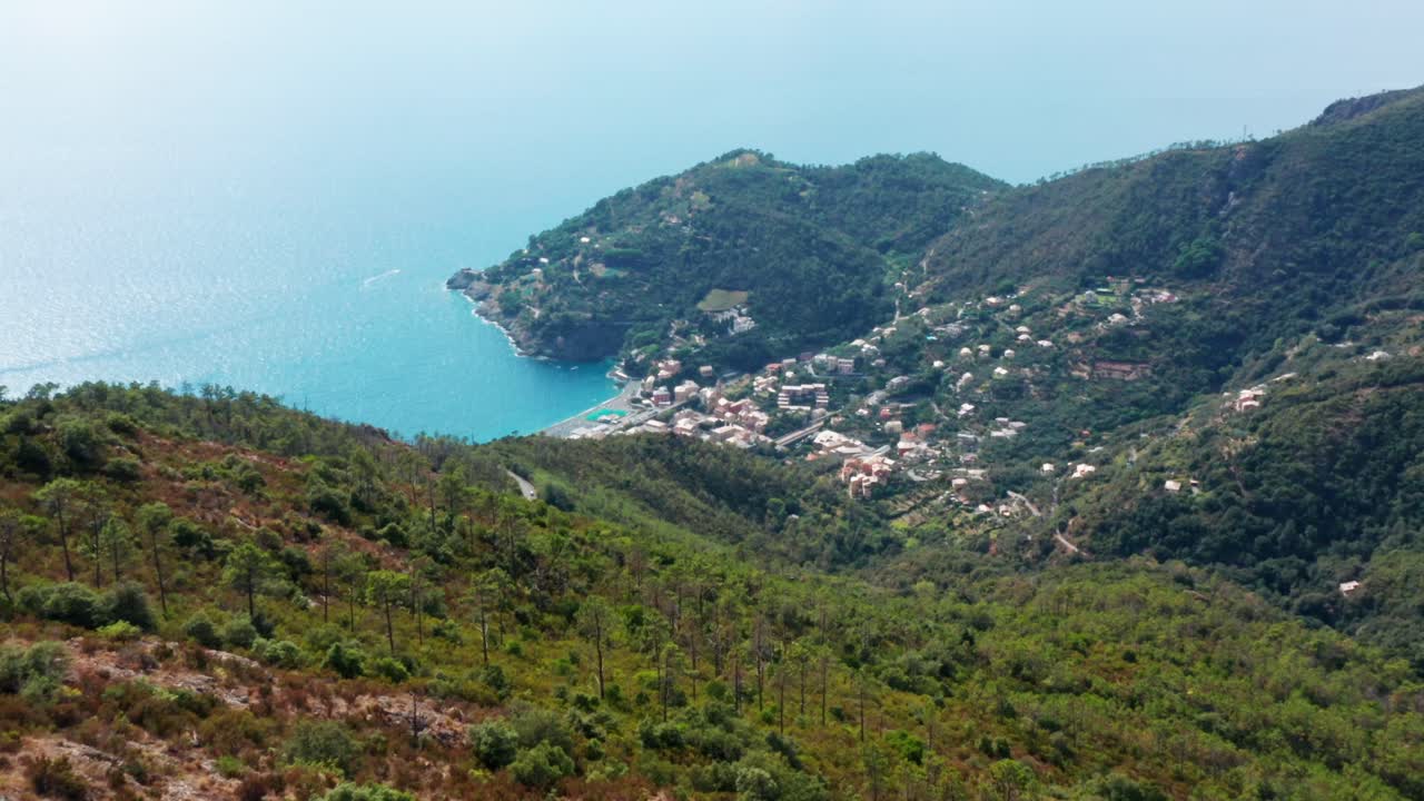 Drone flight over Mediterranean mountain landscape with sunny coastal town in valley, drone aerial panorama