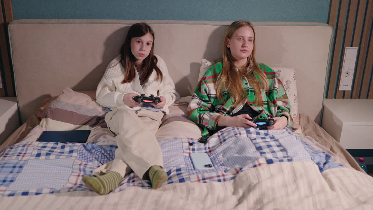 Teen Girls Playing Video Games in Bed