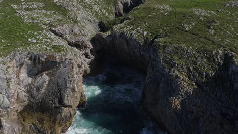 bufones de pria asturias spain erosion cavern, aerial dolly tilt down top down view