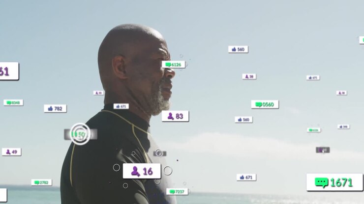 Animation of notification icons over african american senior man walking at beach against clear sky