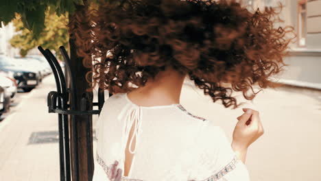 stylish woman with curly hair in the city