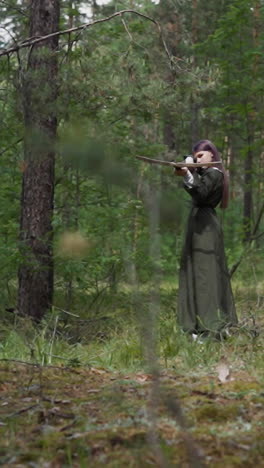 girl archer in long dress shoots crossbow with soft arrow at quest in green fir forest. historical games and children education. medieval age style