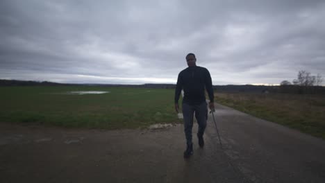 modern black swordsman warrior awaiting battle opponent in open field under grey sky, europe, 4k | muscular, intimidating, shadow, figure, blurry, dark clothes, powerful, blurry to in focus, walk near