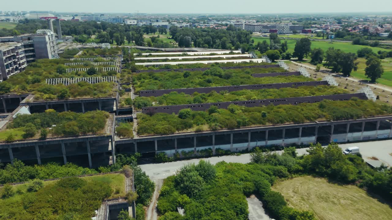 aerial - overgrown industrial ruins near Zagreb Croatia beside fields and scattered vehicles