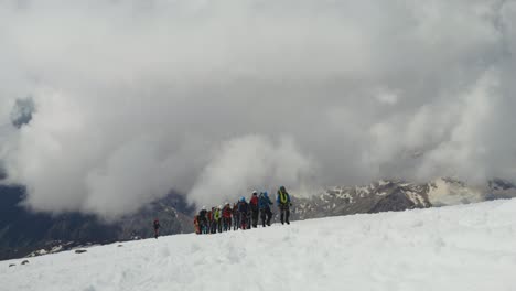 group of climbers ascending a snowy mountain summit