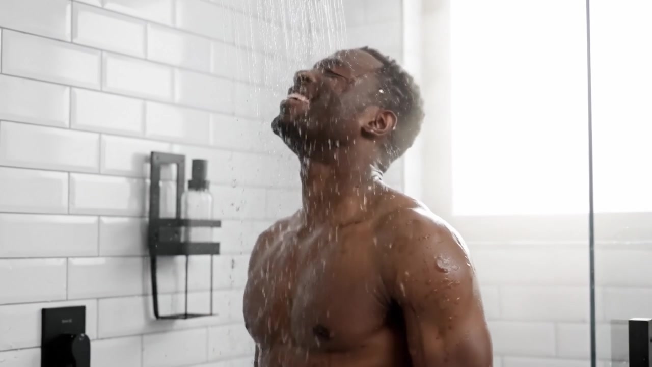 A Man Enjoying a Refreshing Shower Experience, Embracing a Moment of Relaxation and Rejuvenation Under a Flowing Water Stream in a Modern Bathroom Setting
